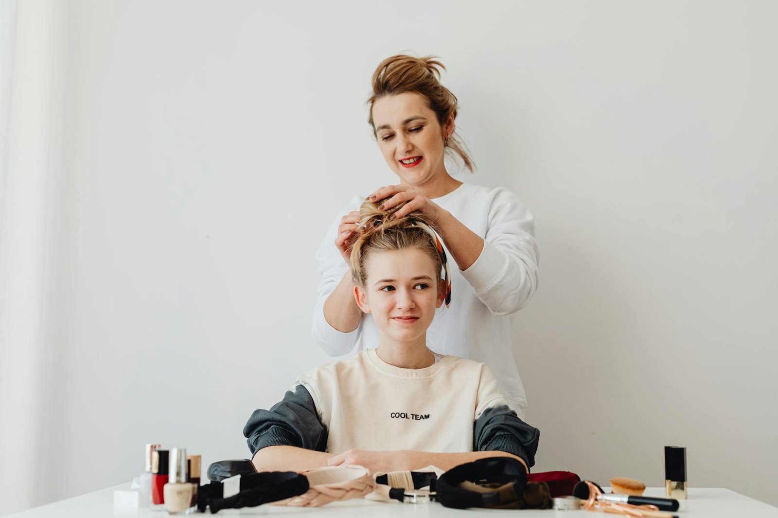 mother doing hairstyle for daughter